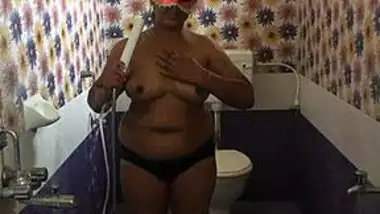 Fat Indian female with a mask on her face performs porn showering